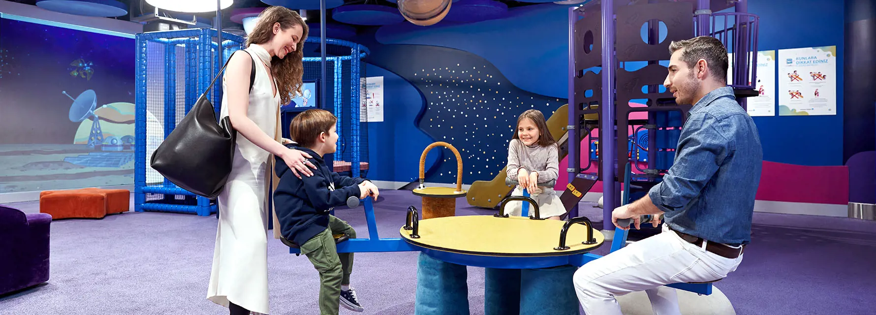 a family playing games with their son in playground in istanbul airport