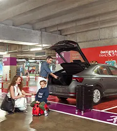 kiraladıkları arabadan valiz indirenbir aile görseli